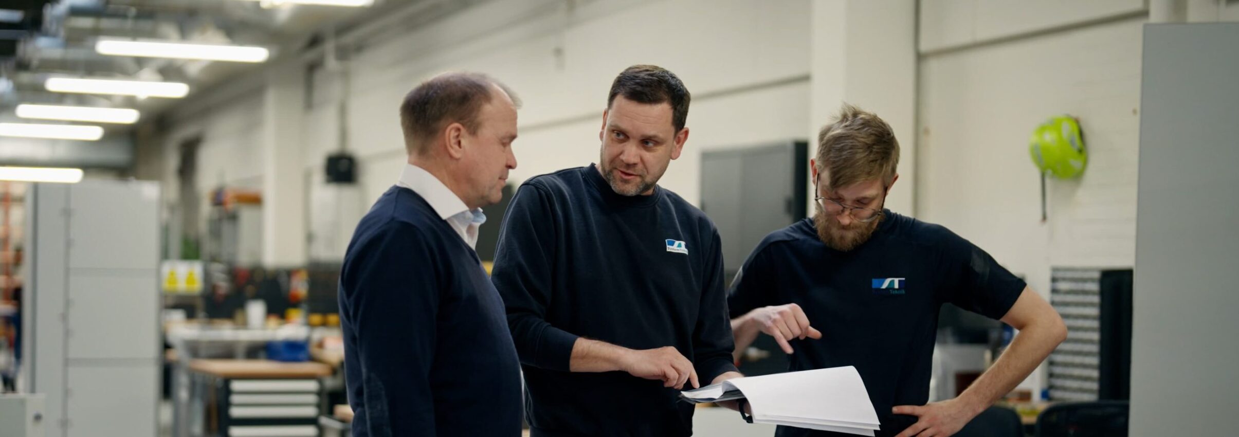 Medarbejdere gennemgår tegninger i produktionen