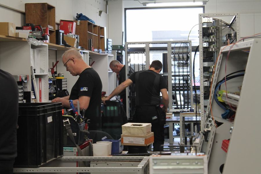 Medarbejdere monterer tavler i produktionen
